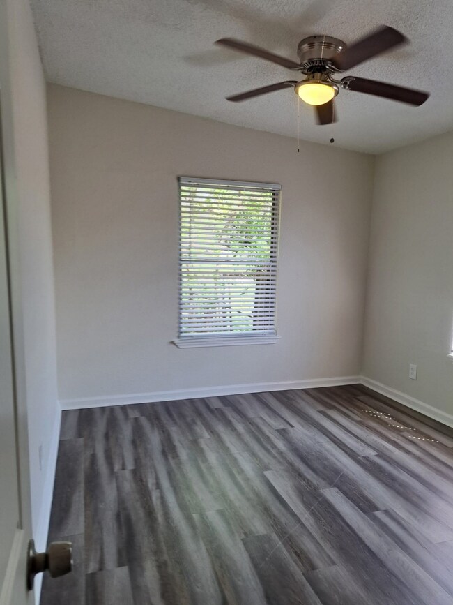 Bedroom 2 with ceiling fan and no carpet