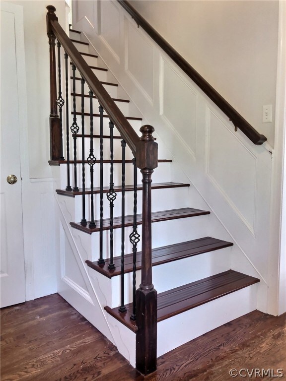 Wood Staircase in the Foyer has wrought iron spind