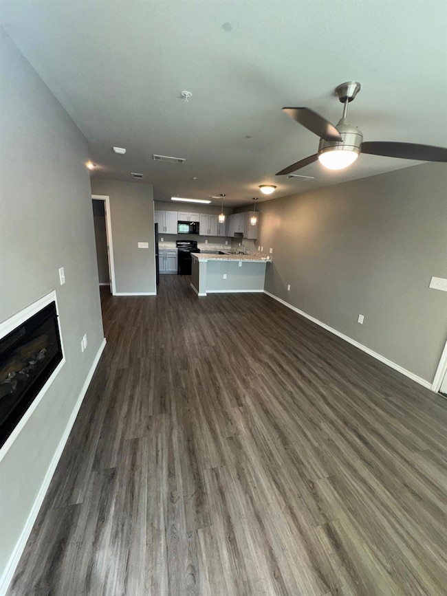 Unfurnished living room featuring dark wood finish