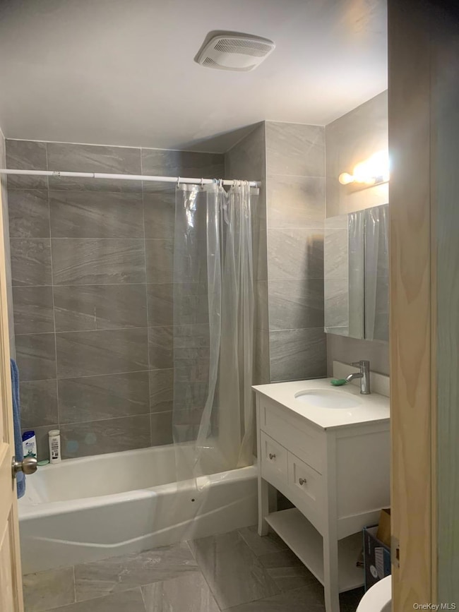 Bathroom with shower / bath combo and vanity