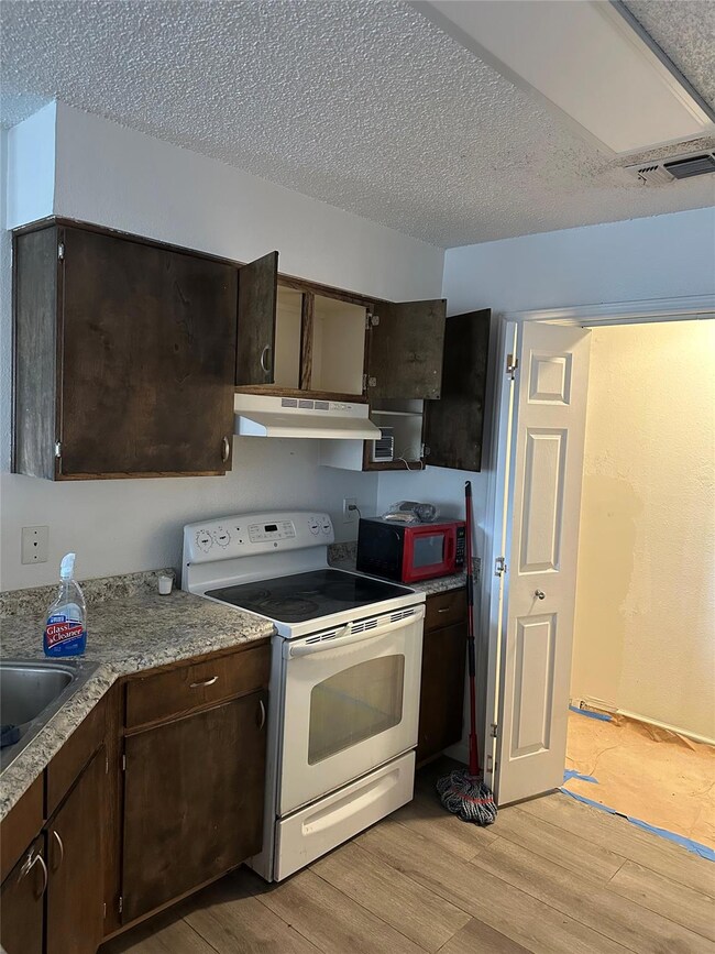 Kitchen with white electric range oven, under cab