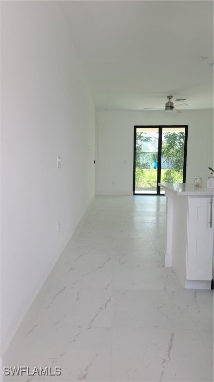 Spare room featuring baseboards, light marble fini