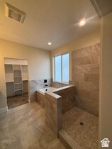Full bath featuring a bath, tile walls, tiled shower, recessed lighting, and a spacious closet
