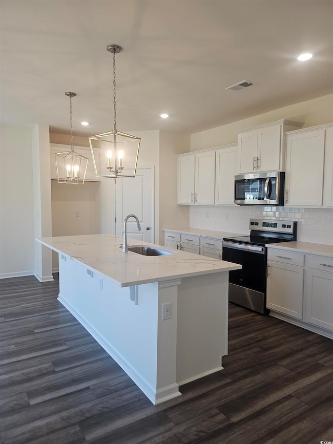 Featuring a beautiful island, pendant lighting and stainless steel appliances