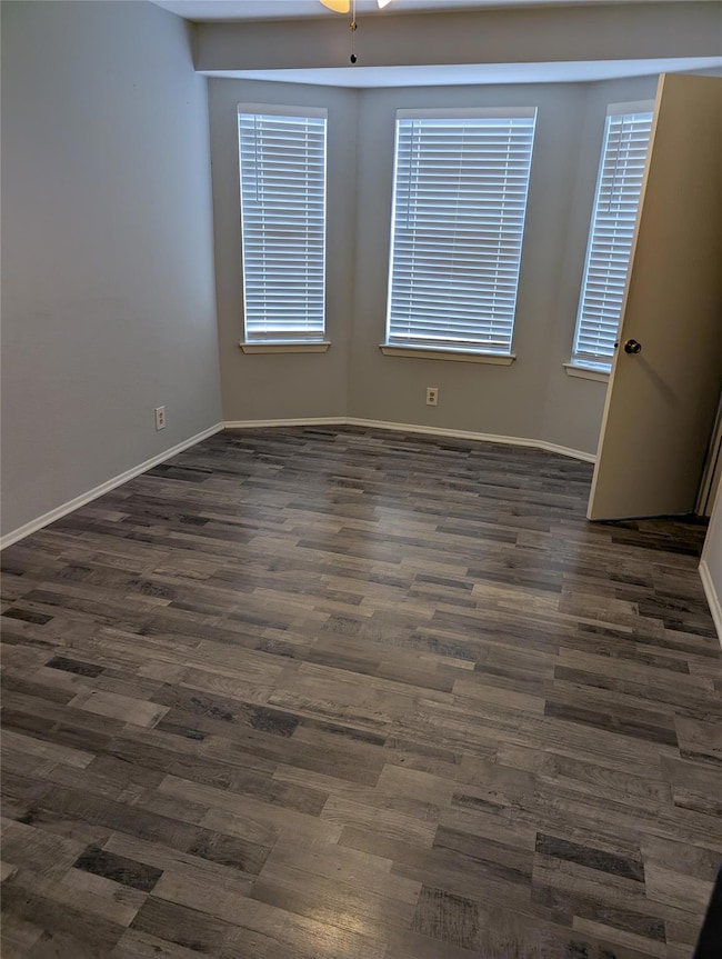 Unfurnished room featuring dark wood-style floori