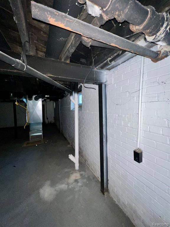 Unfinished below grade area featuring heating unit