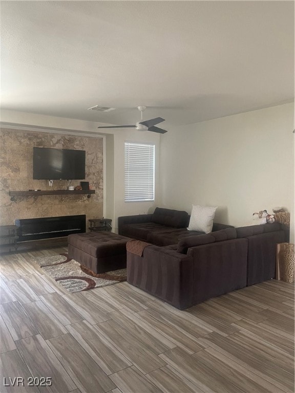 Living room with wood finished floors, a fireplace