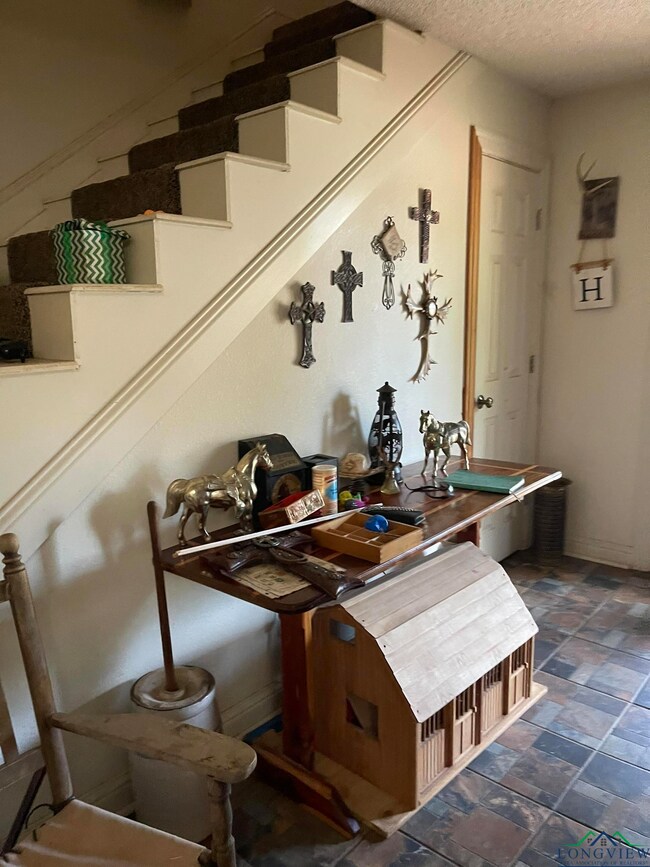 Dining space featuring stairs, a textured ceiling, and stone finish flooring