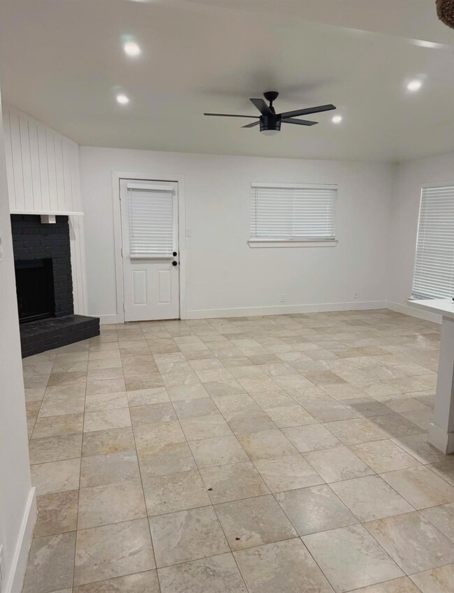 Unfurnished living room with a ceiling fan, reces