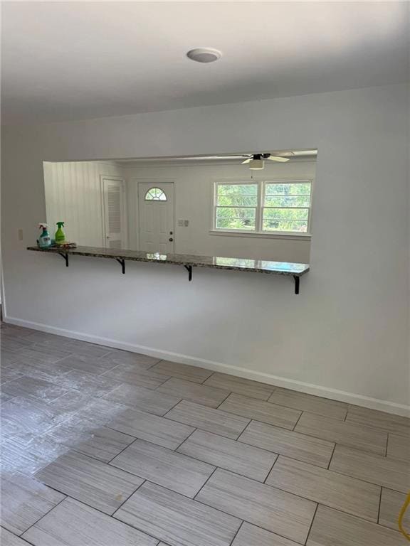 Empty room with baseboards and wood tiled floors