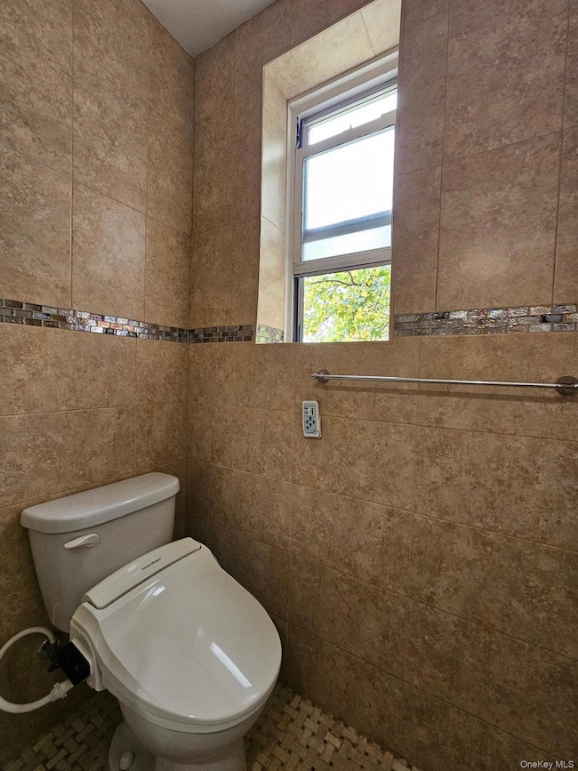 Bathroom featuring tile walls and tile patterned flooring