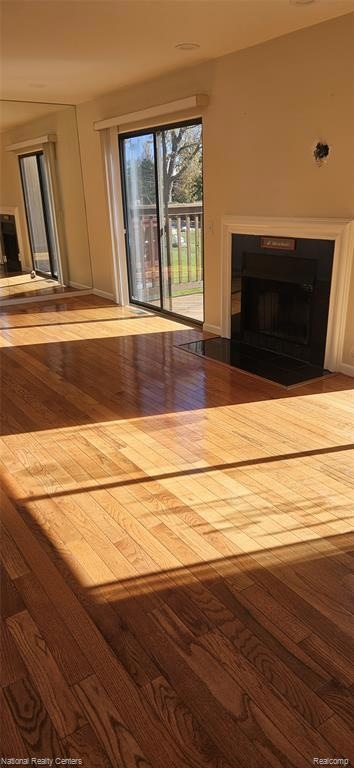 Living room featuring wood finished floors, healthy amount of natural light, and a fireplace