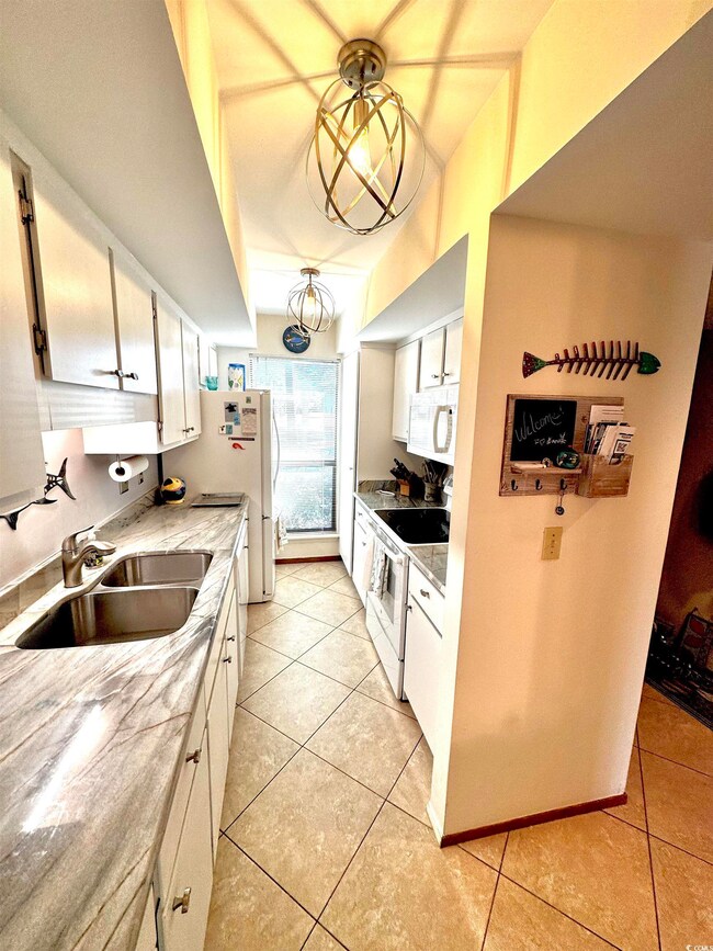 Kitchen featuring white appliances, light tile pat