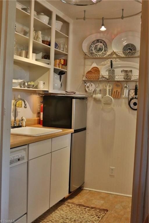 Kitchen features tile floors, upper level open shelving, dishwasher and large sink.  Beadboard and moulding add extra charm to the kitchen.