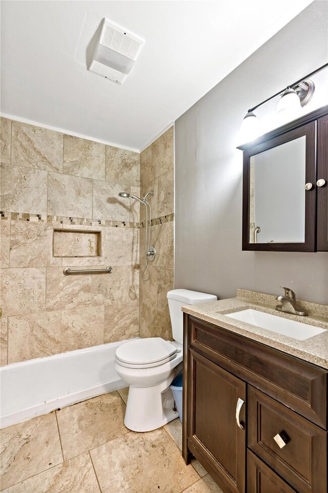 Full bathroom featuring toilet, visible vents, a t