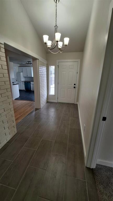 Side entrance foyer with chandelier & lofted ceili