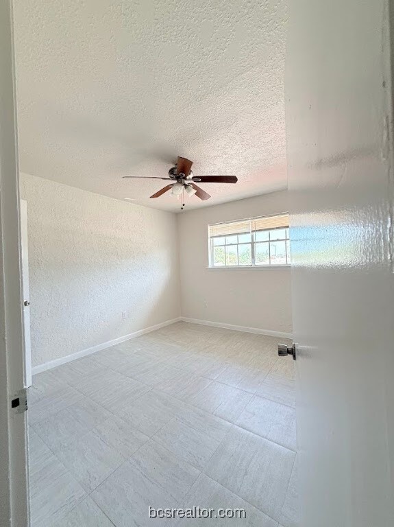 Unfurnished room featuring a textured ceiling and a ceiling fan