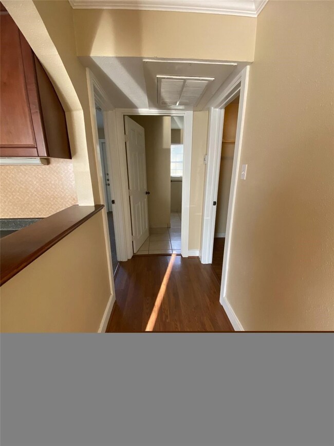 Corridor with dark wood-style floors and ornamental molding