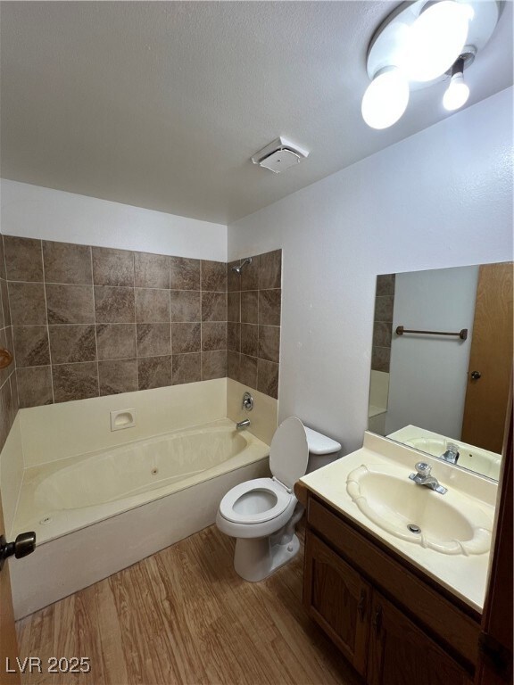 Bathroom featuring wood finished floors, toilet, v