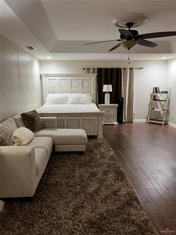 Bedroom featuring dark wood-style floors, baseboards, and ceiling fan