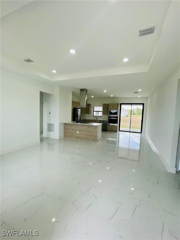 Unfurnished living room with baseboards, marble fi