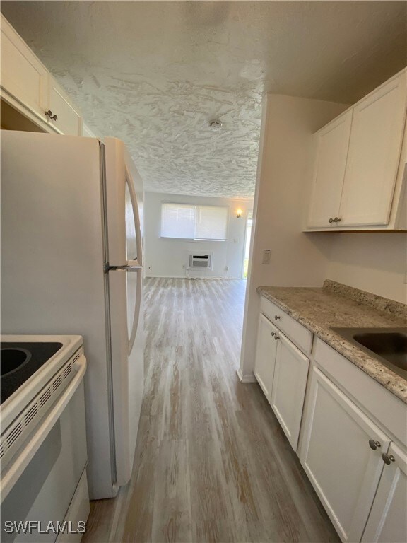 Kitchen featuring white electric stove, wood finis