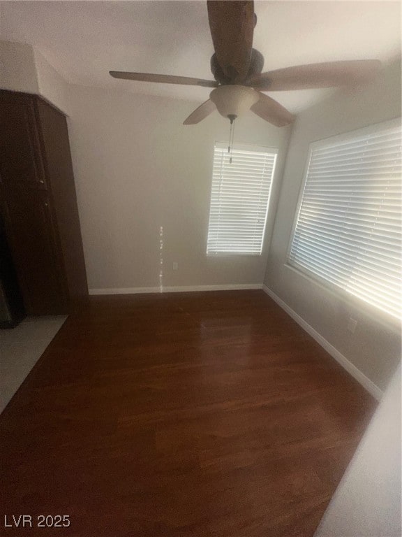 Empty room with dark wood-style flooring and baseboards
