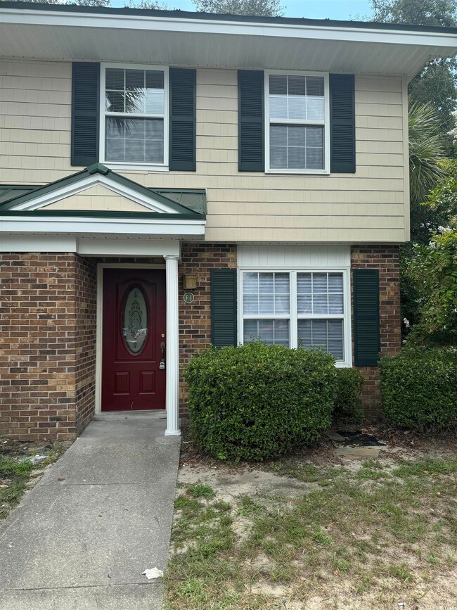 Doorway to property featuring brick siding