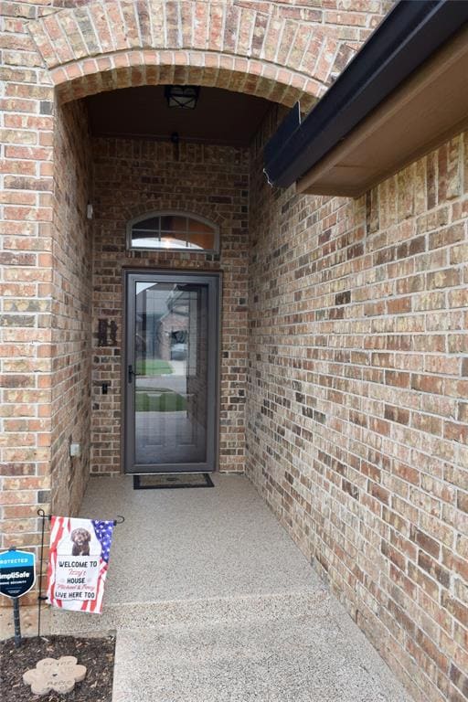 Doorway to property with brick siding