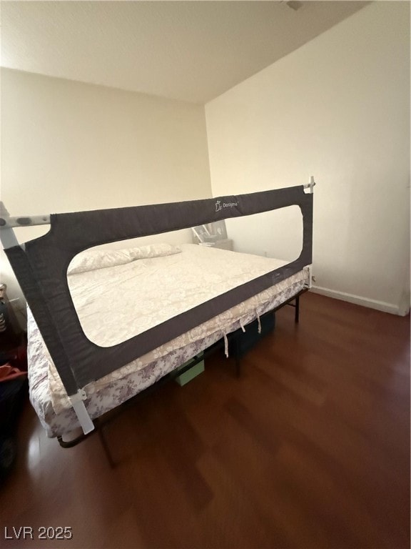 Bedroom featuring wood finished floors and baseboa