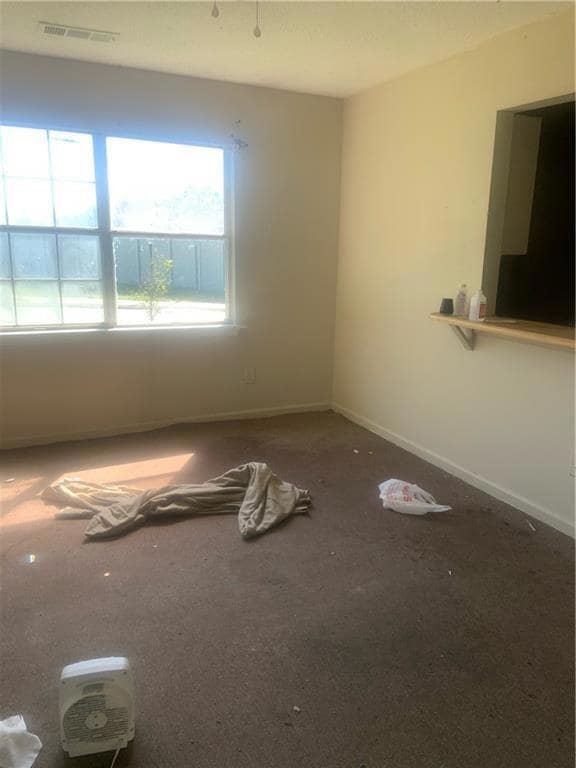 Empty room featuring visible vents and baseboards