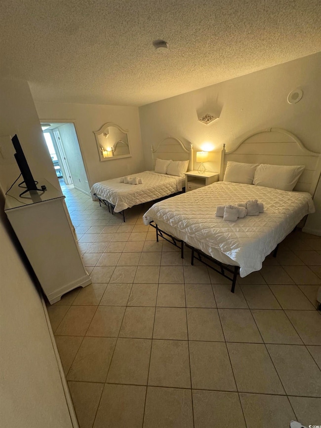 Bedroom with light tile patterned flooring and a t
