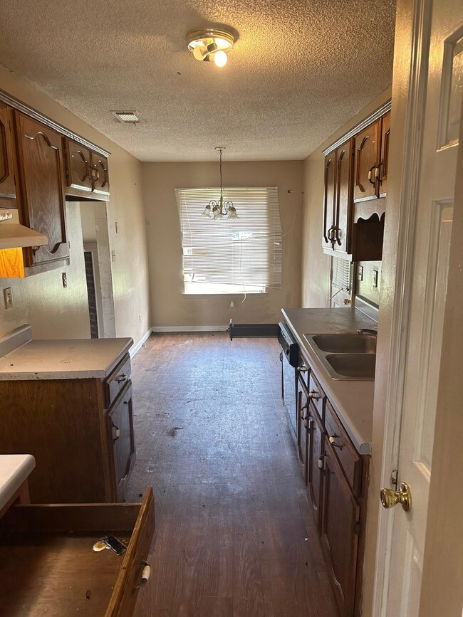 Kitchen featuring wall chimney range hood, sink, p