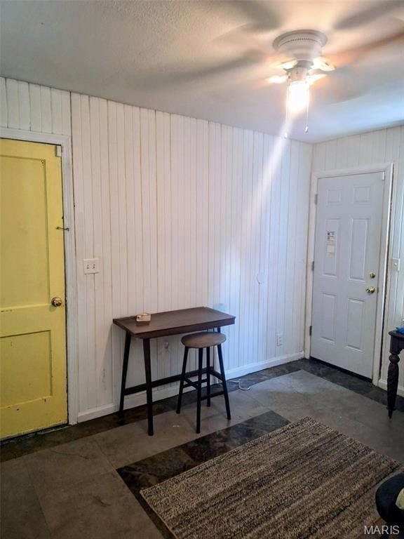 Entrance foyer with wooden walls and ceiling fan