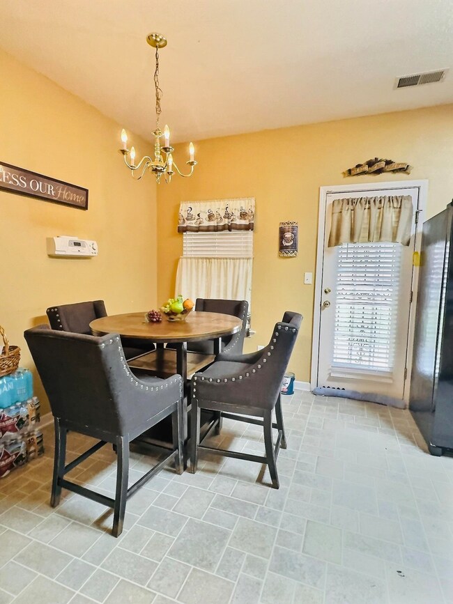 Tiled dining room with a notable chandelier