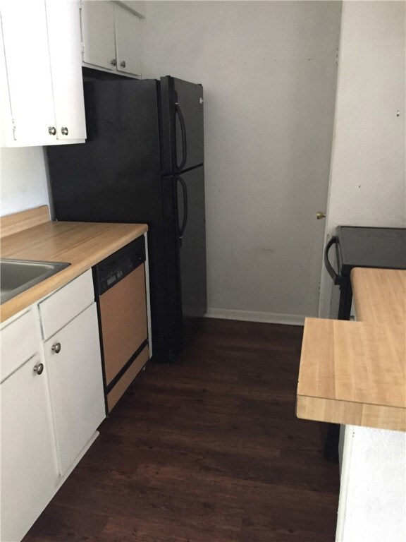 Kitchen with white cabinets, dark wood-type floori