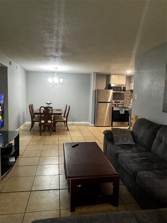 Living room with baseboards, an inviting chandelie