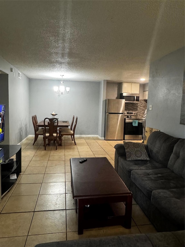 Living room with baseboards, an inviting chandelie