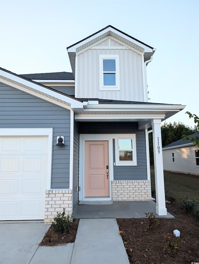 View of front of house featuring covered porch, board and batten siding, and a garage