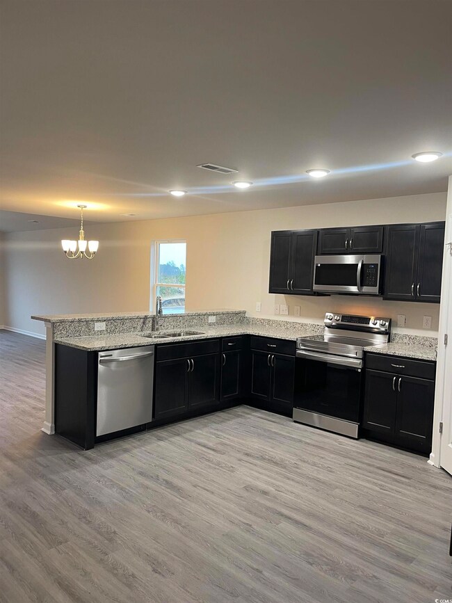 Kitchen featuring sink, kitchen peninsula, stainle