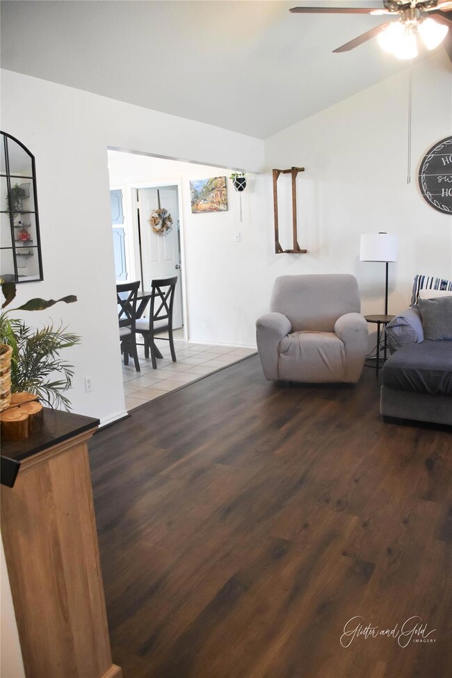 Living area with lofted ceiling, ceiling fan, and 