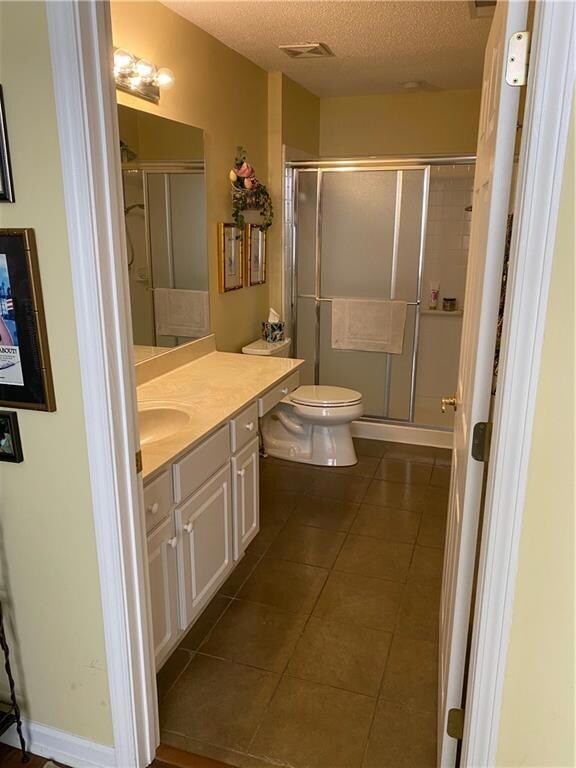 Bathroom featuring a textured ceiling, toilet, a s