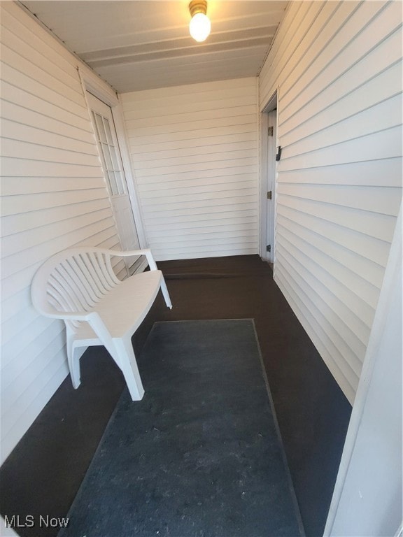 Unfurnished sunroom featuring wood walls