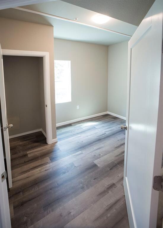 Unfurnished room featuring wood finished floors and baseboards