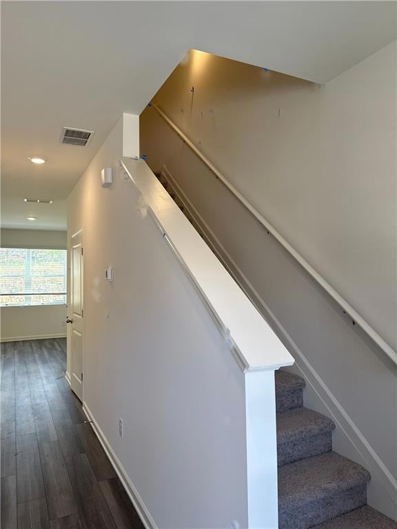 Stairway featuring wood finished floors, baseboards, and recessed lighting