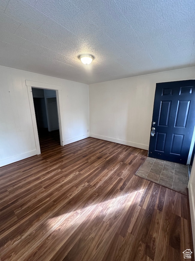 Foyer with dark hardwood / wood-style floors and a textured ceiling