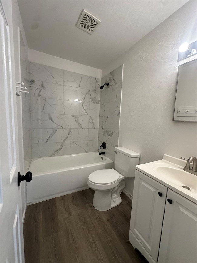 Full bath featuring vanity, wood finished floors,