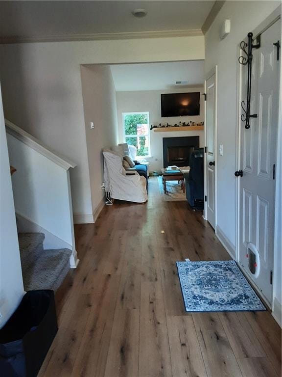 Wide entry foyer with wide plank flooring, and crown molding