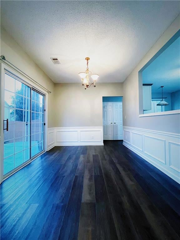 Unfurnished room featuring a notable chandelier, v