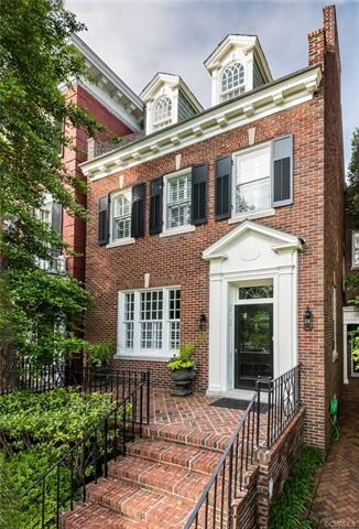 Morning light shines on the facade and welcoming brick front porch.  Perfect for entertaining and parade viewing.